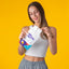 Woman taking a white patch out of a CHEAL Multivitamin Patch pouch
